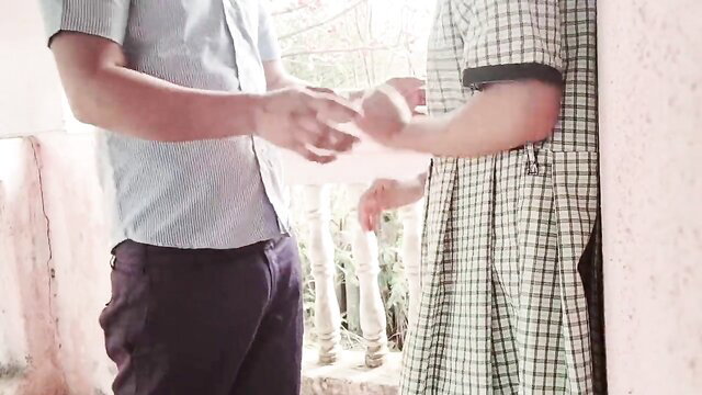 Indian college girl in checkered dress holds hands with guy outdoors