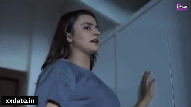 Gorgeous nymph in tight blue tee poses seductively by wardrobe