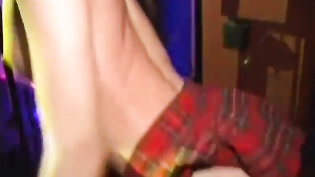 Kinky brunette in red plaid skirt bending over in club, upskirt tease