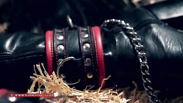 Captured pony girl in red leather cuffs, chains, black boots and fetish gear