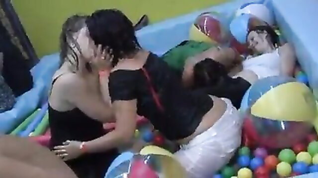 Wet brunettes and blondes in lesbian kiss and group play in ball pit orgy