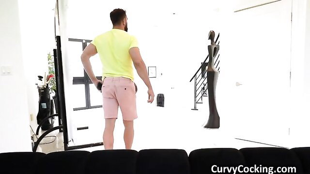 Muscular bearded man in yellow tank top and pink shorts in art studio