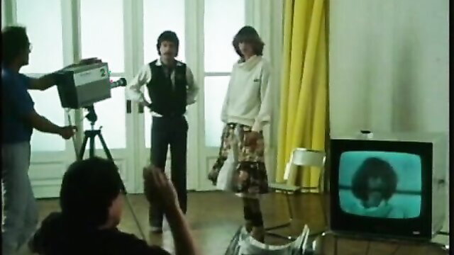 Retro 70s porn shoot: Jenny in skirt, director filming TV closeup