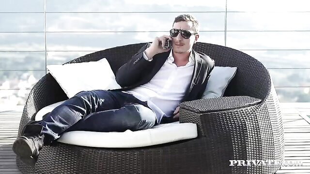Man in shades relaxes on lounge chair overlooking city in sexy pose