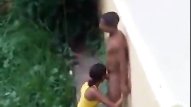 Brazilian couple outdoor voyeur sex: black woman kneels sucking nude man's cock