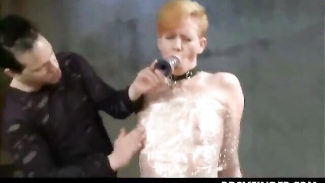 Redhead in collar covered in whipped cream toyed by man on stage