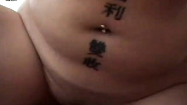 Ginger girl with navel piercing and Chinese tattoos on belly