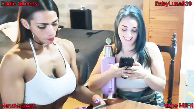 Buff Latina and blue-haired girl smile in skimpy tops, teasing phone POV