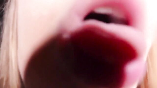 Close-up of blonde licking lens in seductive ASMR Diddly style