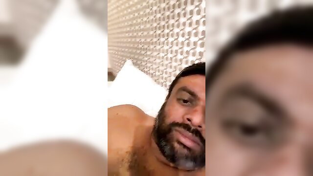 Blurry selfie of shirtless Indian man with beard in bed