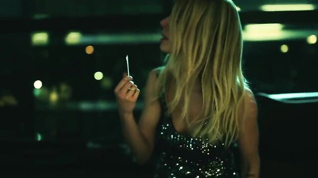 Blonde bombshell in sparkly dress holds cigarette, Burning Betrayal nude scene