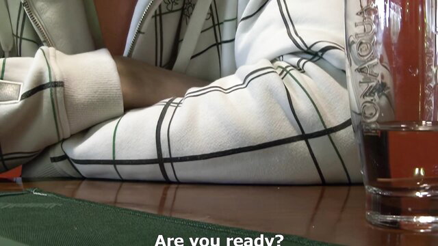 Fidelity testing Monika in white plaid tracksuit sipping drink at table