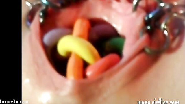 Mature woman stretches pussy with colorful dildos and jelly beans