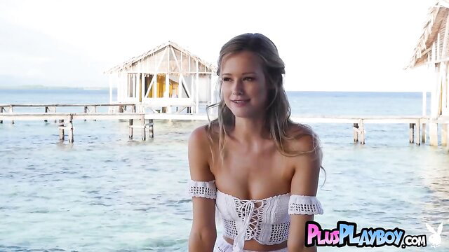 Blonde bombshell in white crochet bikini on tropical beach
