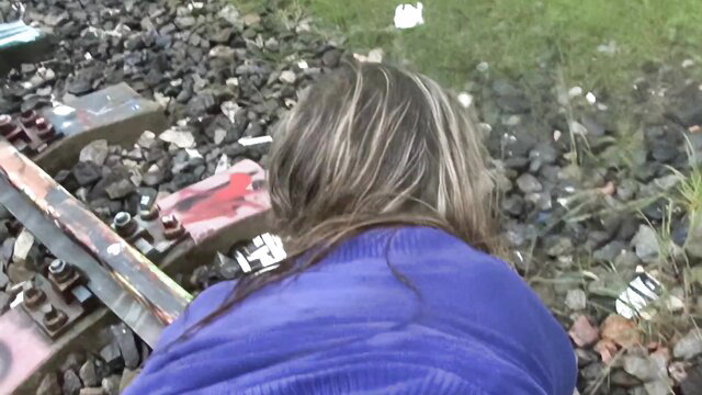 Veronika fidelity testing on train tracks, bending over in tight blue coat