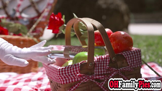 Picnic girl in white gloves offers ripe apples from basket