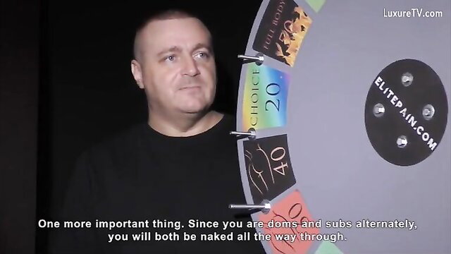 Elite Pain Very Painful 3 man speaks to camera by spin wheel in BDSM game