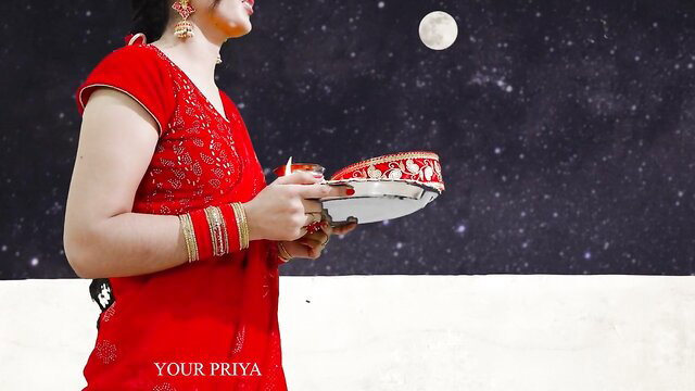 Priya in red saree holds Karva Chauth thali under moonlit sky
