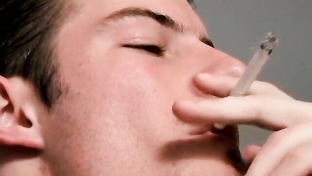 Gorgeous Mike Roberts smoking with eyes closed, hand near mouth