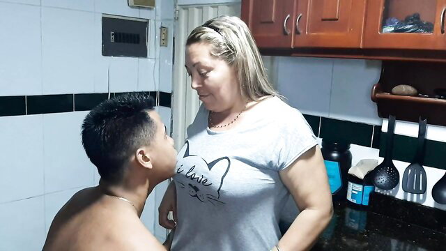 Excited busty blonde stepmom teases topless guy in kitchen