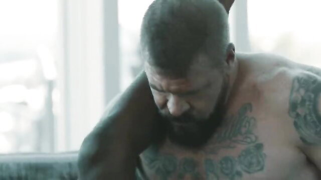 Tattooed muscular bearded hunk Rocco in intense bare embrace with Liam