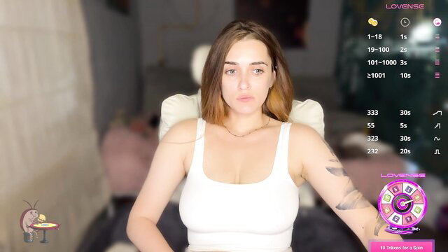 Brunette camgirl in tight white tank top with big boobs, tattoos, Lovense show
