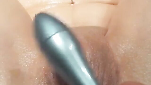 Closeup of silver vibrator penetrating bound sub's wet shaved pussy