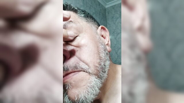 Close-up of mature bearded man picking nose in amateur video thumbnail