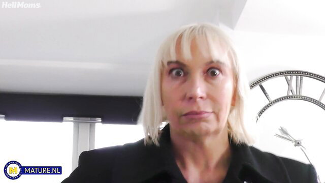 Blonde MILF with big tits in black suit on video call, sexy gaze