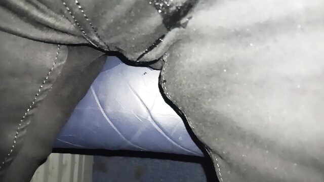 Pee accident closeup on plane: wet shiny latex pants crotch leak