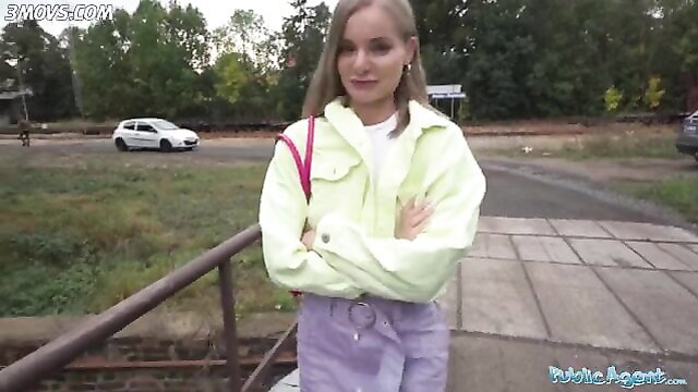 Slim blonde in yellow jacket and purple skirt poses outdoors, hungry for huge cock