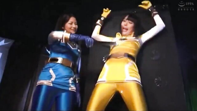 Asian women in shiny blue and yellow latex suits posing seductively