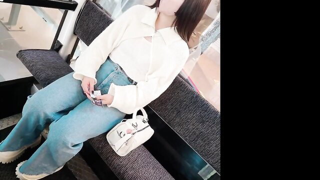 Asian woman in white blouse and blue jeans sitting with bag, candid amateur pose