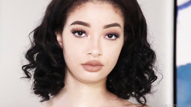 Beautiful mixed Black model Bloom with curly black hair, sultry gaze