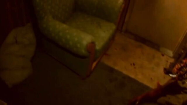 Blurry green armchair in dimly lit room, Unholy Ground 2016 horror nude scene