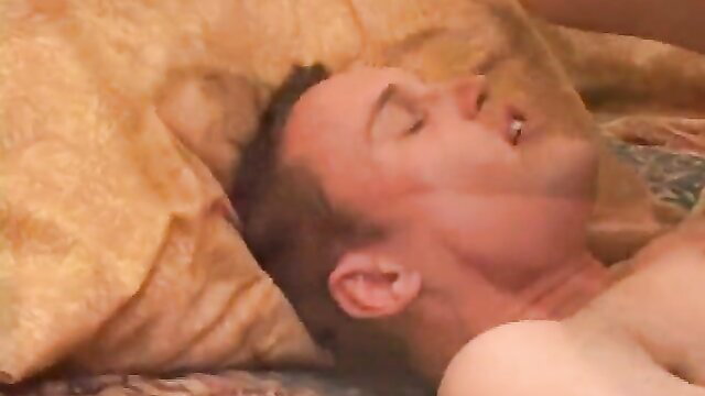 Man lying on bed with mouth open in ecstasy, closeup face