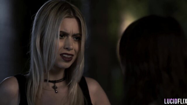 Blonde Jill Kassidy in black tank top smirks in tense Lucid Things scene