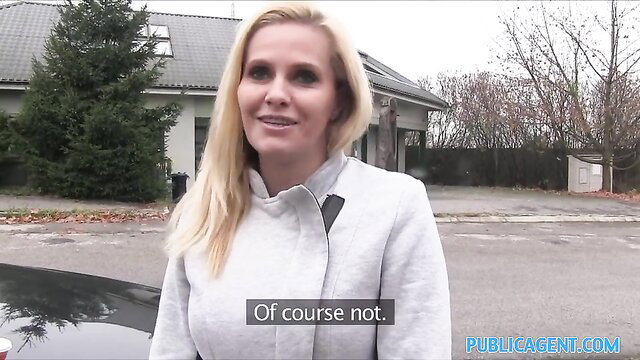 Blonde MILF in gray coat smiles outside car, Public Agent amateur