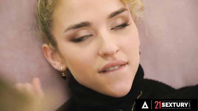 Blonde turtleneck cutie with piercing eyes smirking closeup in lesbian threesome