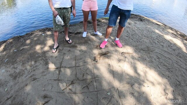 Lilly Bell in tiny pink shorts with guys outdoors by river
