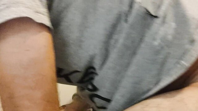 Blurry closeup of woman's gray tank top with black scribble text in amateur porn thumbnail