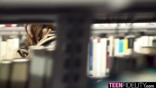 Lena Anderson nerdy teen peeking through bookshelf in library