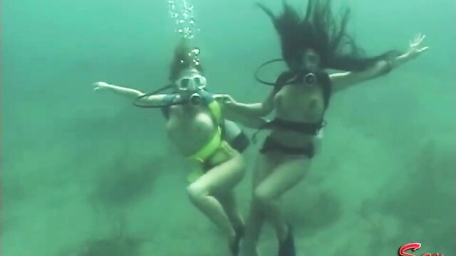 Two busty naked Asian girls in bikinis scuba diving underwater