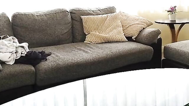 Beautiful wife on gray couch with tossed clothes, immoral apartment tease