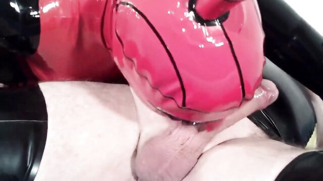 Latex rubber crossdresser in pink mask sucks cock closeup