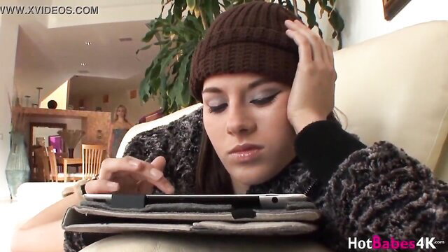 Cherie DeVille in knit beanie and cardigan on couch, cougar tease