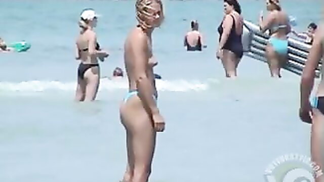 Women in bikinis at a crowded beach