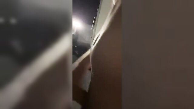 Blurry night shot of hand near white wall in public street tease