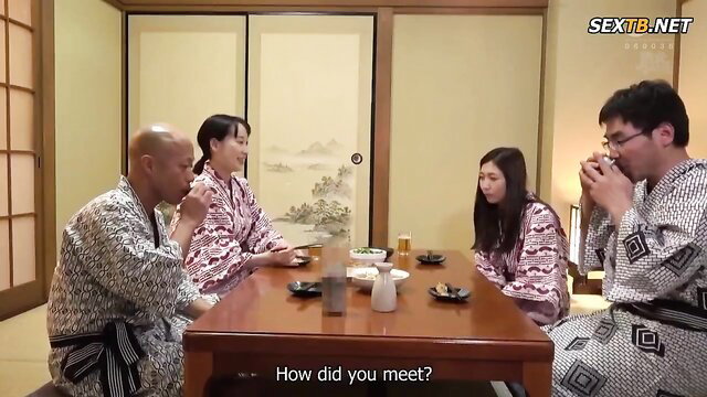 Japanese couple in kimono with bald man at dinner table on holiday