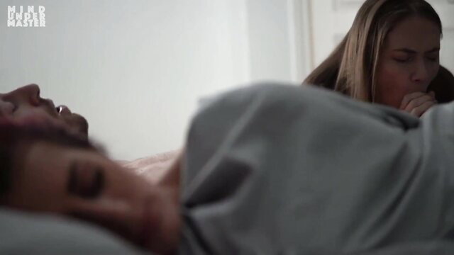 Blonde woman watches brunette man sleep in bed, mind control tease